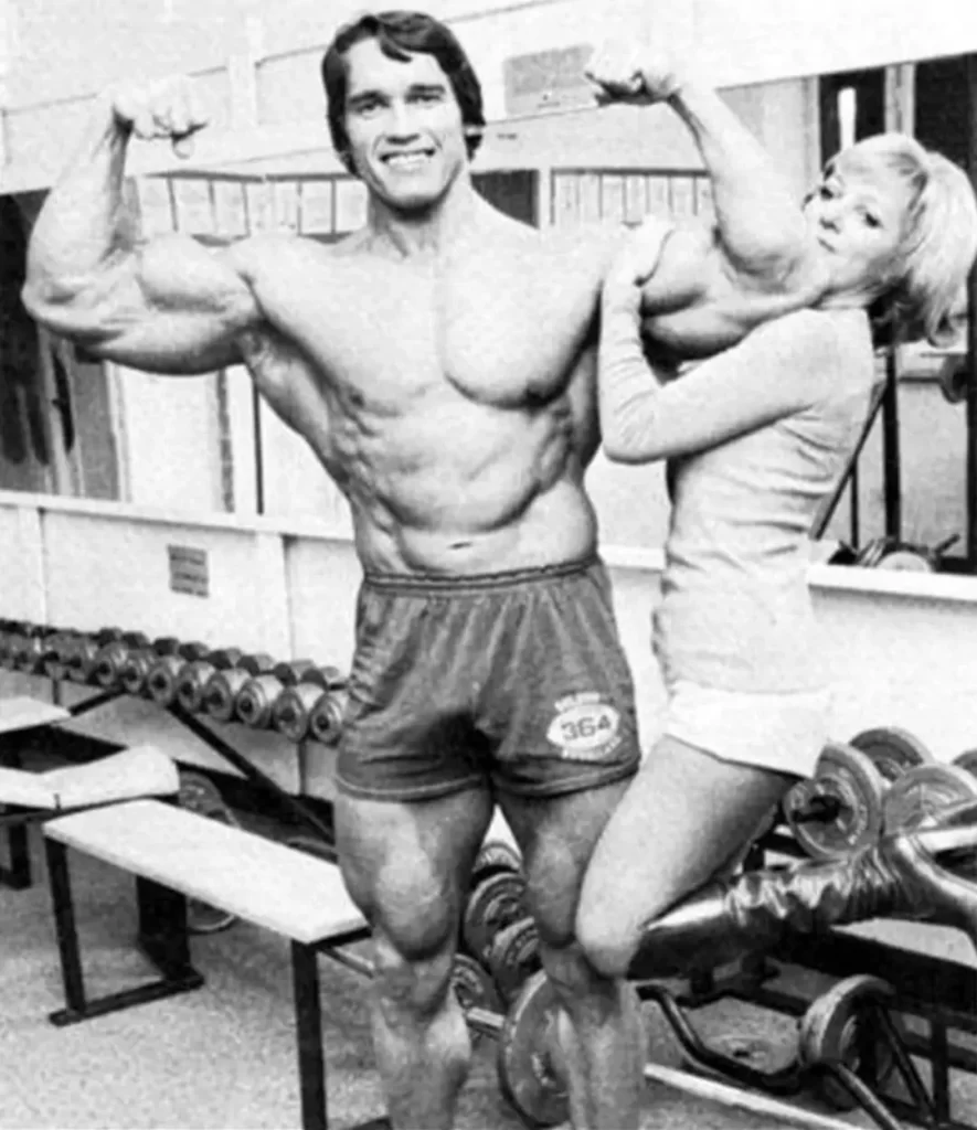 Arnold lifting his girlfriend in the gym